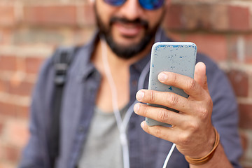 Image showing man with earphones and smartphone on street