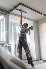 Image showing Plasterer renovating indoor walls and ceilings. Construction finishing works.