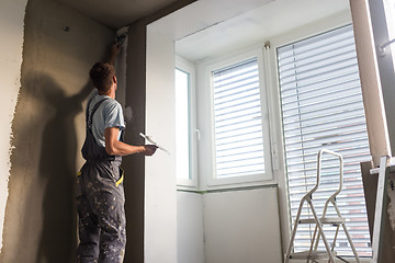 Image showing Plasterer renovating indoor walls and ceilings. Construction finishing works.