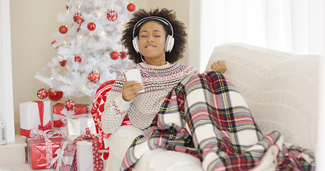 Image showing Happy woman listening to music on Christmas Day