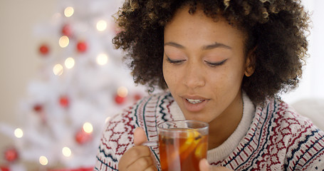 Image showing Young woman sipping a cup of hot lemon tea