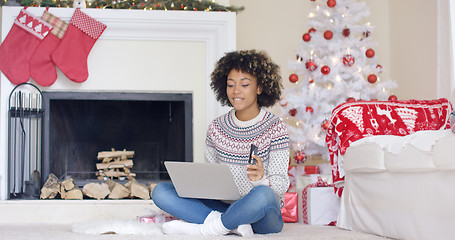 Image showing Young woman doing Christmas shopping online