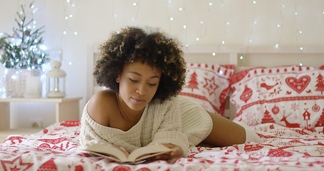 Image showing Calm beautiful African woman reading in bed