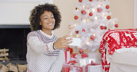 Image showing Happy young woman posing for a Christmas selfie