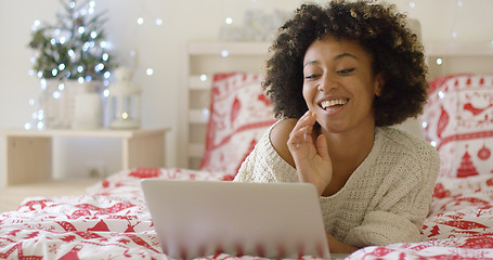 Image showing Beautiful woman in bed laughing at computer