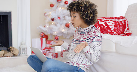 Image showing Cute young woman having a video chat at Christmas