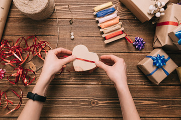 Image showing Crop hands decorating present