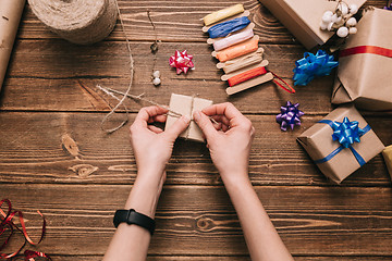 Image showing Crop hands decorating present