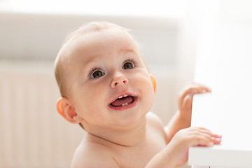 Image showing happy little baby boy or girl at home looking up