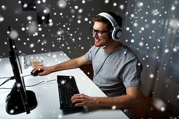 Image showing man in headset playing computer video game at home