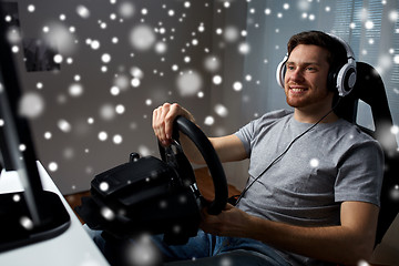 Image showing man playing car racing video game at home