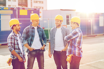Image showing group of smiling builders in hardhats outdoors