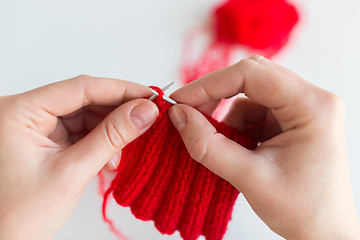 Image showing close up of hands knitting with needles and yarn