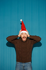 Image showing Surprised christmas man wearing a santa hat