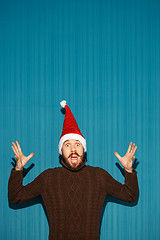 Image showing Surprised christmas man wearing a santa hat