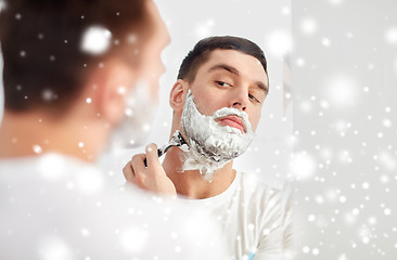 Image showing man shaving beard with razor blade at bathroom