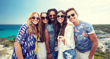 Image showing happy hippie friends with selfie stick on beach