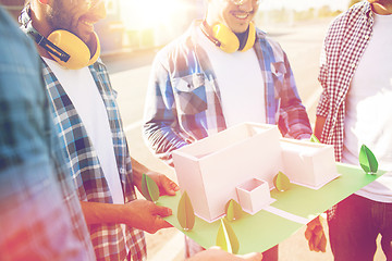 Image showing close up of builders with paper house model