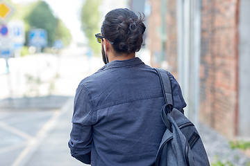 Image showing man with backpack walking along city street