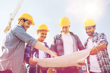 Image showing group of builders with tablet pc and blueprint