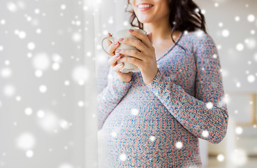 Image showing close up of pregnant woman with tea cup at window