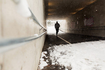 Image showing man running along subway tunnel in winter