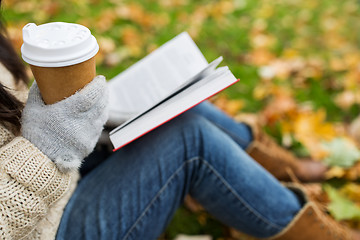 Image showing woman with book drinking coffee in autumn park