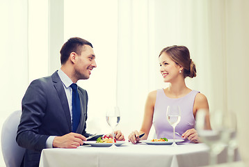 Image showing smiling couple eating main course at restaurant