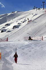 Image showing Skier ascend on snow ski slope at sun evening