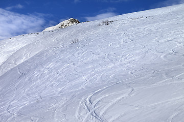 Image showing Off-piste slope with track from ski and snowboard in sunny morni