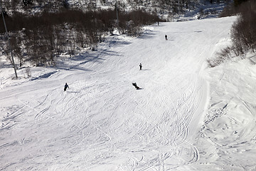 Image showing Snowboarders and skiers on ski slope at sun winter day