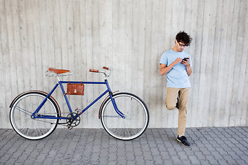 Image showing man with smartphone and earphones on bicycle