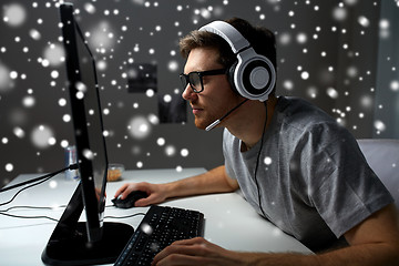 Image showing man in headset playing computer video game at home