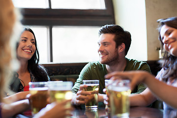 Image showing happy friends drinking beer at bar or pub