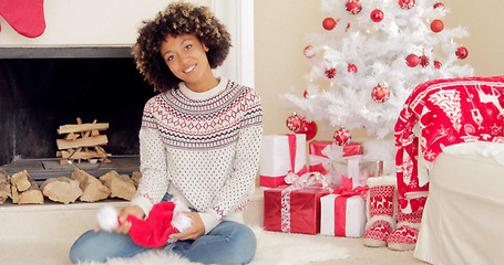 Image showing Smiling young woman holding a Santa hat