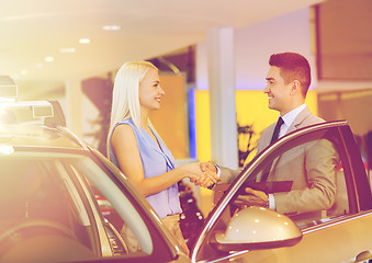 Image showing happy woman with car dealer in auto show or salon