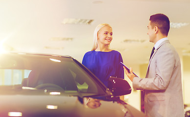 Image showing happy woman with car dealer in auto show or salon