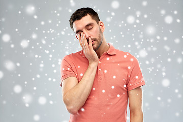 Image showing tired sleepy man over snow