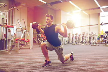 Image showing young man flexing muscles with barbell in gym