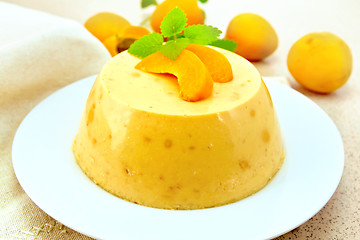 Image showing Panna cotta apricot with mint and fruit on table