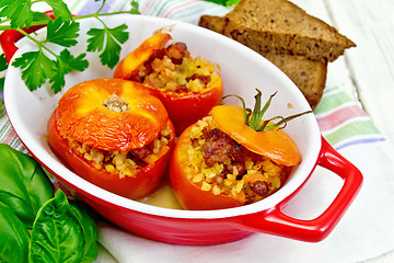 Image showing Tomatoes stuffed with bulgur in pan on board