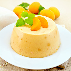 Image showing Panna cotta apricot with fruit and mint on table