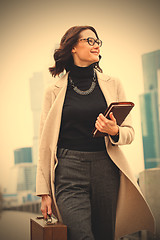 Image showing Smiling beautiful middle-aged woman goes in a white coat 