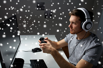 Image showing man in headset playing computer video game at home