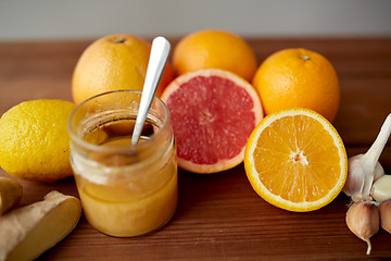 Image showing honey, citrus fruits, ginger and garlic on wood
