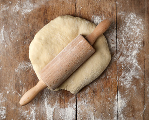 Image showing fresh raw dough and rolling pin 