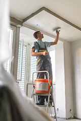 Image showing Plasterer renovating indoor walls and ceilings. Construction finishing works.