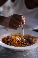 Image showing a young African American woman eating pasta