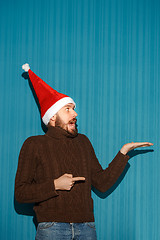 Image showing Surprised christmas man wearing a santa hat