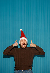 Image showing Smiling christmas man wearing a santa hat